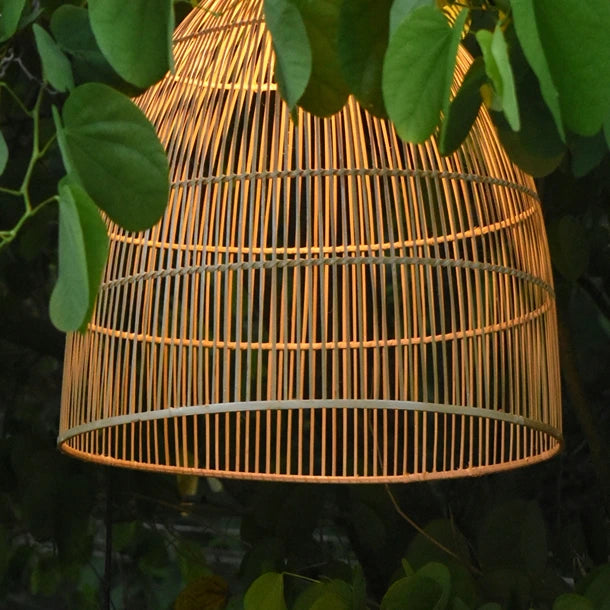 Aura Bamboo Lamp Hanging Outdoors Among Greenery