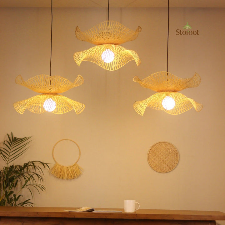 Three bamboo hanging lamps cluster with a warm glow on a beige wall, featuring the Storot brand.