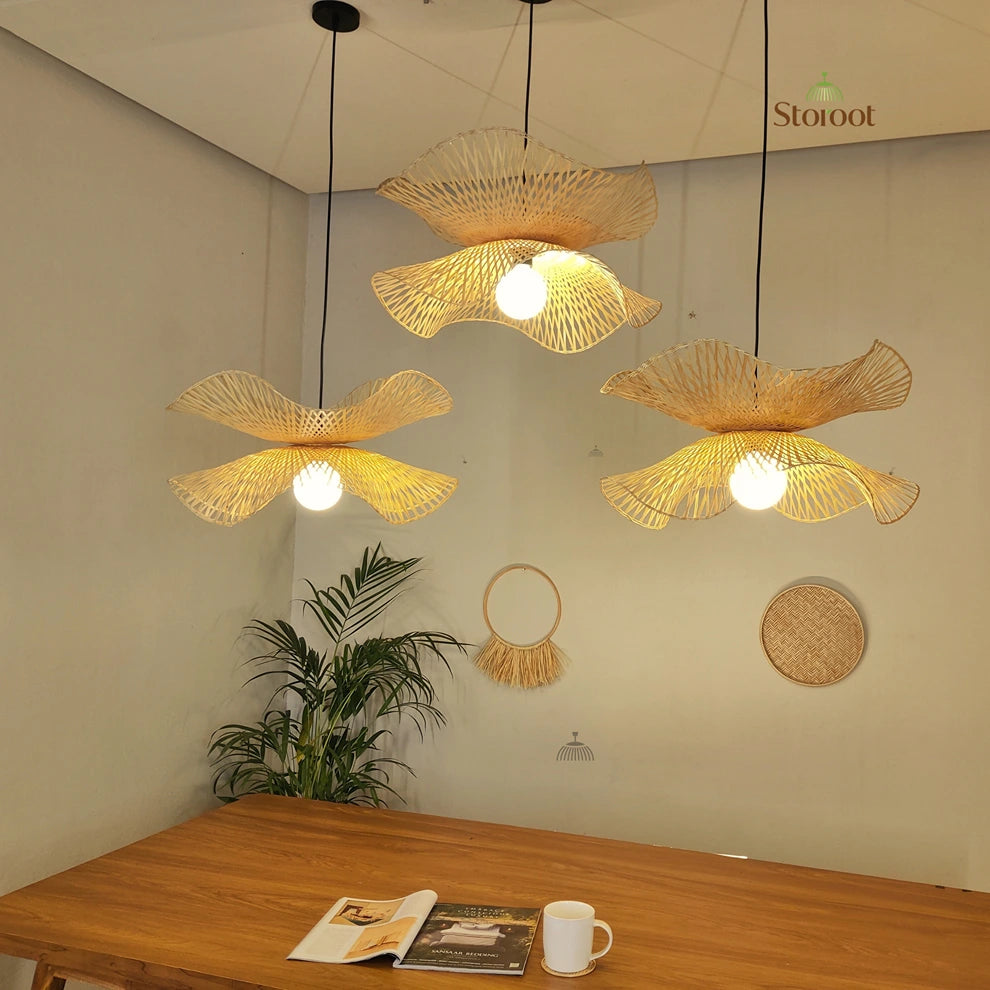 Woven Bamboo pendant lights hanging above a wooden table with decor items.