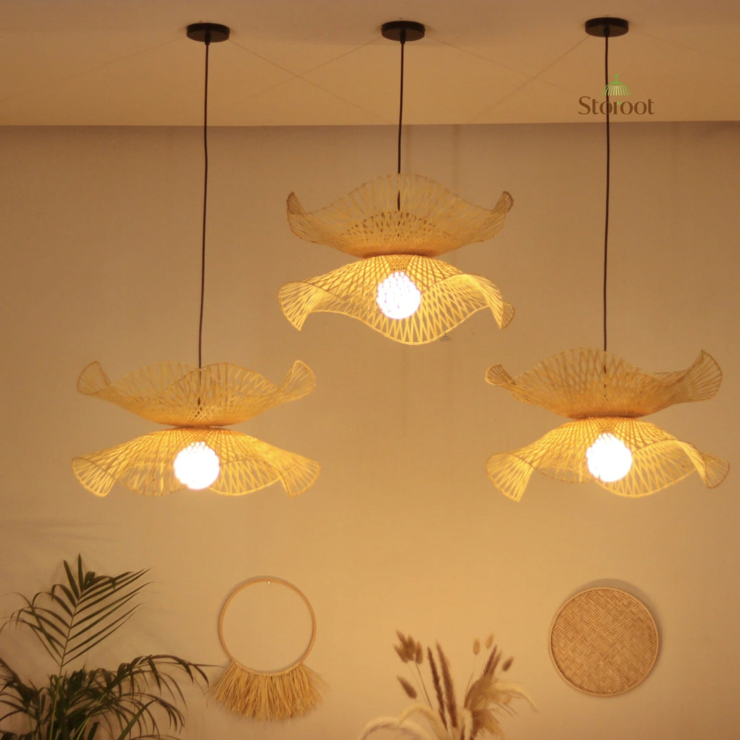 Three hanging bamboo pendant lights cluster with a warm glow on a beige boho wall