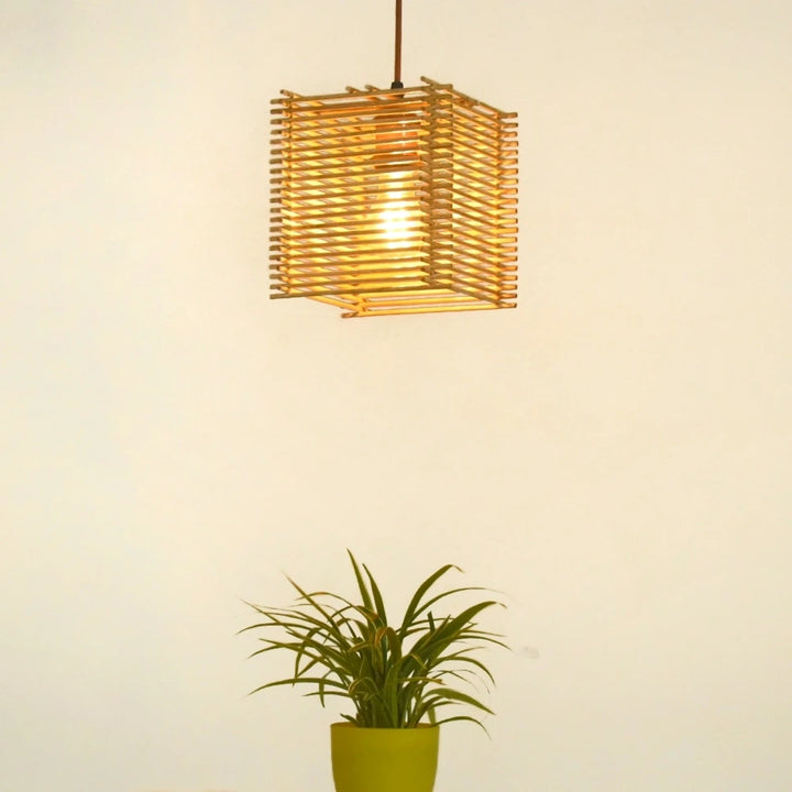 LightNest Square Pendant Light illuminating a room - A warm, glowing pendant light made from bamboo, hanging in a cozy room setting.